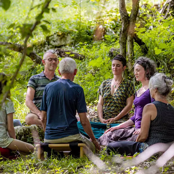 Groupe de personnes en méditation en pleine nature dans la forêt lors d'une retraite de méditation en Drôme