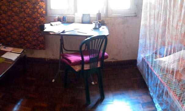 Espace de la chambre pendant le séjour au monastère avec un lit un bureau et une chaise devant une fenêtre